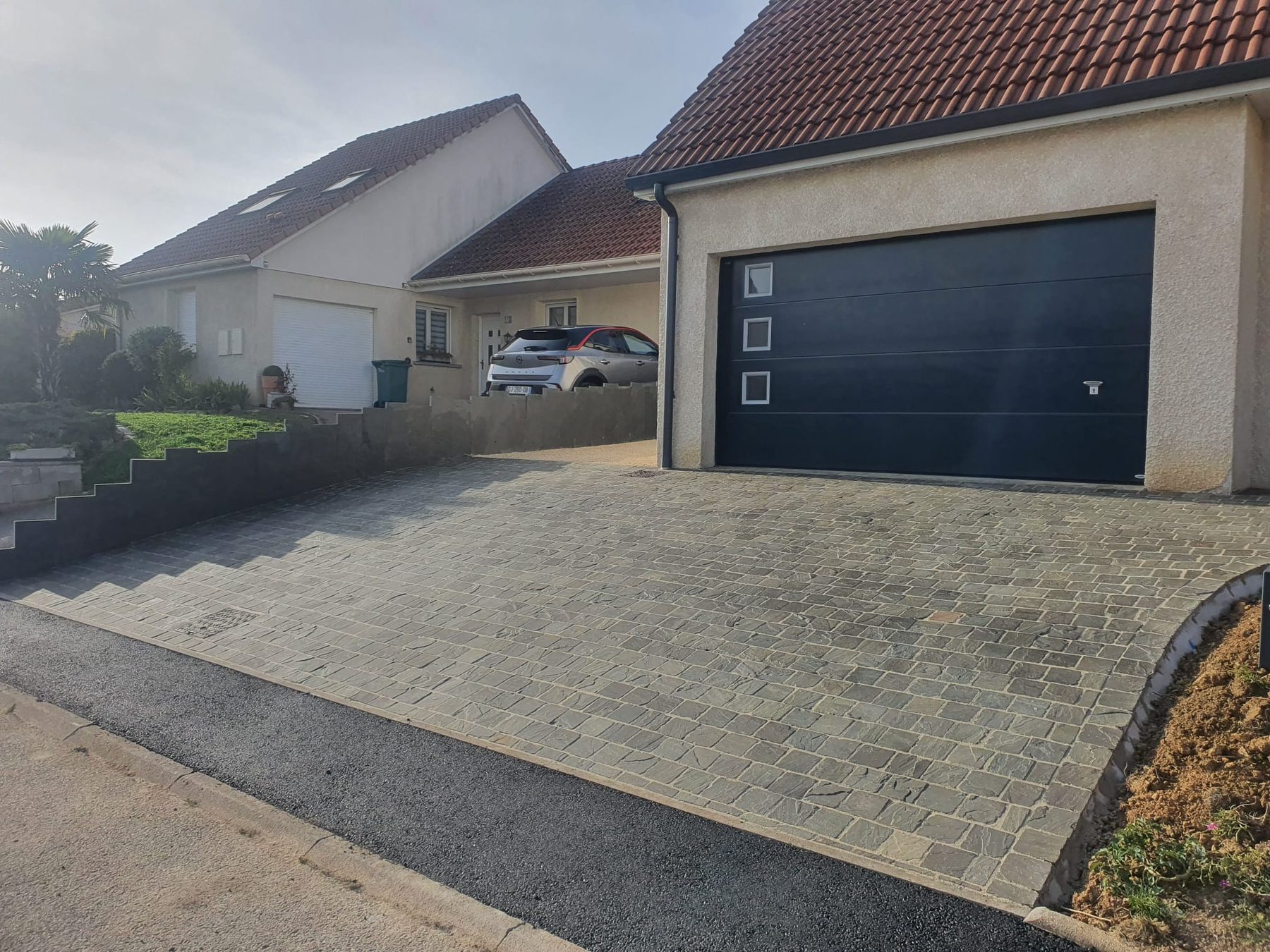 Cour pavée devant un garage