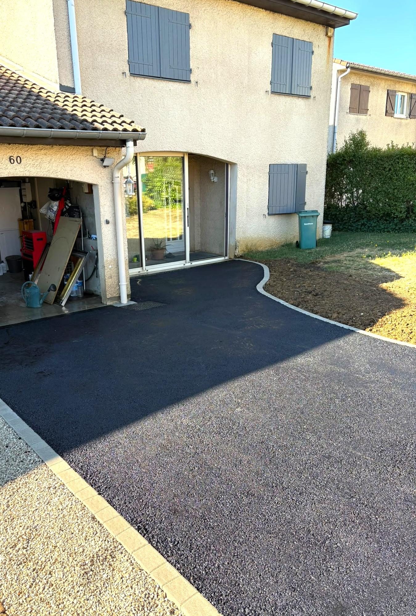 Allée en enrobé bordée qui longe la pelouse
